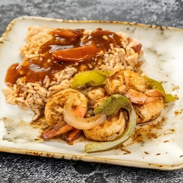 Jerk N Go's Jamaican shrimp with rice, peppers, and onions, drizzled with sauce.