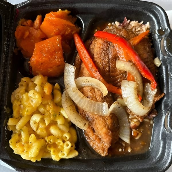 Jerk N Go's Jamaican meal with mac and cheese, candied yams, and brown stew chicken with peppers and onions.