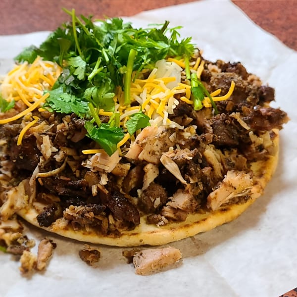 Jerk N Go's Jamaican flatbread topped with shredded jerk chicken, cheese, and cilantro.