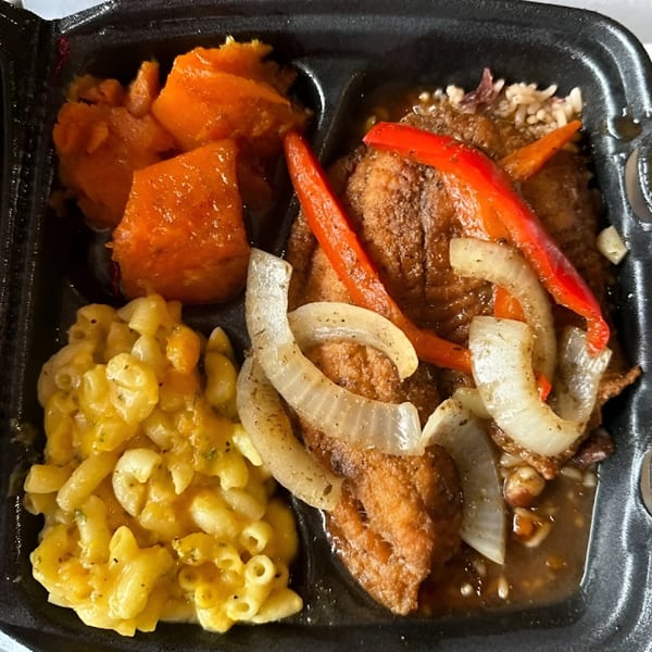 Jerk N Go's brown stew chicken with red peppers, onions, mac and cheese, and candied yams.