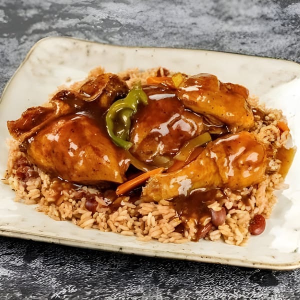 Jerk N Go's brown stew chicken with rice and peas, topped with gravy and vegetables.