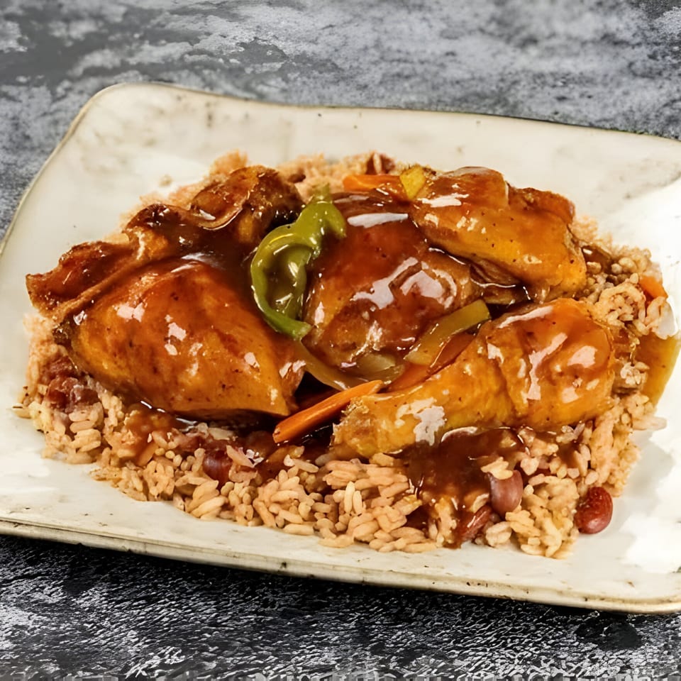 Jerk N Go's brown stew chicken with rice and peas, garnished with peppers and carrots.